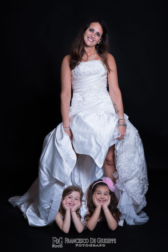 Servizio fotografico per la famiglia, mamma indossa l'abito da sposa con i suoi bambini. Fotografie ed emozioni della tua famiglia